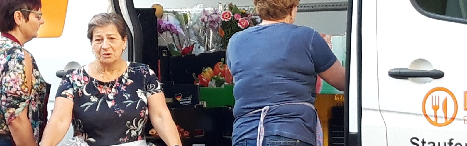 Drei Frauen entladen einen Bus der Tafel Staufen
